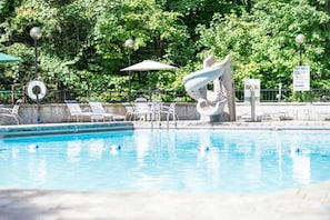 A swimming pool with lounge chairs and a lifebuoy. - Honey Bear Lodge, 4BR Family Cabin, Hot Tub, Views, Seasonal Resort Pool (Gatlinburg)