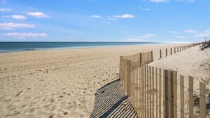 A sandy beach with a wooden fence and a clear blue sky. - A Place in the Sun 301 by seaside Vacations & Sales (Ocean City)