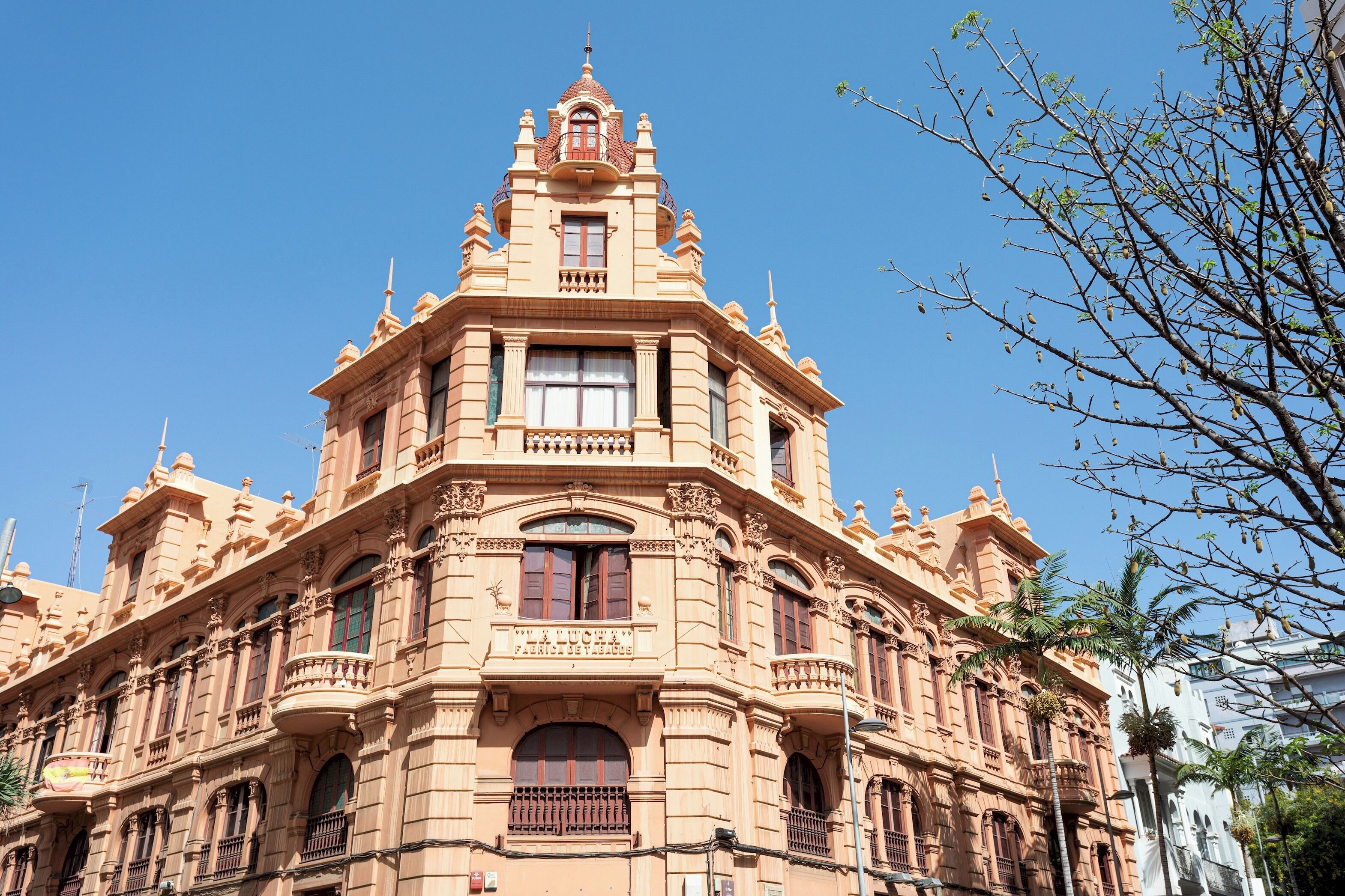 Un edificio histórico con arquitectura ornamentada, varios balcones y grandes ventanales.