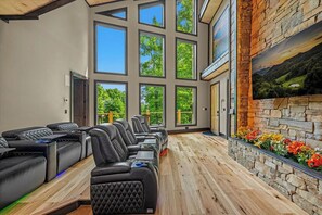 A spa room with multiple massage chairs, large windows, and a stone wall with a painting. - Nestled in the heart of Gatlinburg, "Waterfalls and Wildflowers" offers a serene (Gatlinburg)