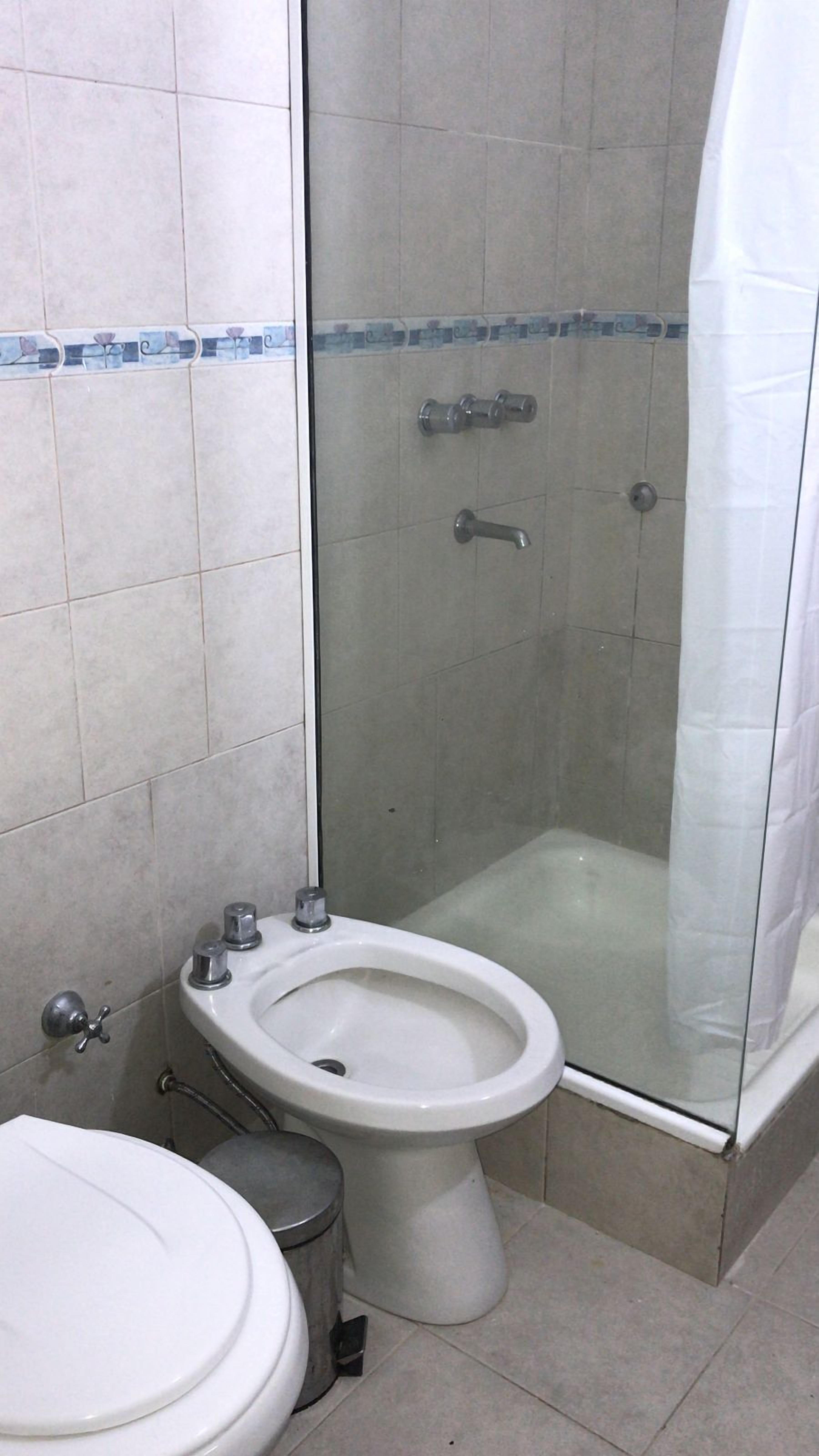 Un bagno con toilette, bidet e cabina doccia in vetro.