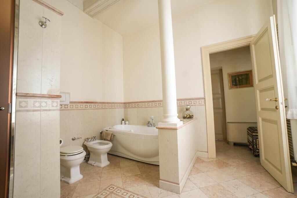 A bathroom with a bathtub, toilet, and bidet.