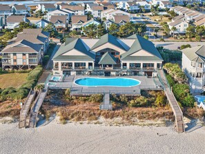 A large resort with a central pool, multiple guest rooms, and a beach access walkway. - Spacious 6BR Retreat | Steps to Beach Access, Elevator, Resort Pool Access (Ocean Isle Beach)