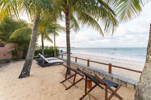 Une plage avec des chaises longues et une rambarde en bois.