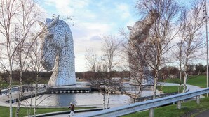 A large, metallic sculpture resembling a head with horns, surrounded by a water body and trees. - Beechtree Lodge 54 (Denny)