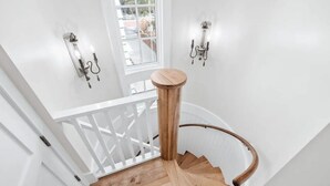 A wooden staircase with white railings and wall sconces. - 🏖️2BR Sea La Vie Seaside • Steps to Private Beach Access•Bikes🏖️ (Santa Rosa Beach)