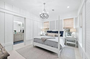 A bedroom with a white four-poster bed, a chandelier, and a nightstand with a lamp. - ⭐Luxury Seaside Home w/ Pool & Spa | Sea La Vie Seaside Main House⭐ (Santa Rosa Beach)