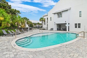 A swimming pool with a tiled edge, surrounded by lounge chairs and a building with multiple windows. - ⛱️Beach Access | Pet Friendly | Azure on 30A 1-205- A Wave From it All⛱️ (Santa Rosa Beach)