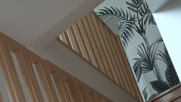 A wooden staircase with a modern design, featuring a geometric pattern on the wall behind it. - Bright apartment in the countryside - private parking (Fontaines-d'Ozillac)