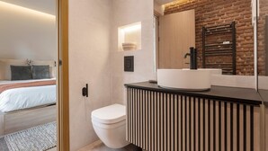 A modern bathroom with a white sink, a black towel rack, and a wooden vanity. - Genteel Home Concha Espina I (Madrid)
