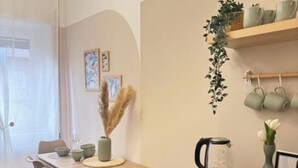 Een eetruimte met een houten tafel, stoelen en een koffiehoek.