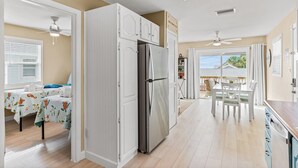 A spacious kitchen with a large refrigerator, dining table, and chairs. - Lou's Starfish Haven - Beach Front (Indian Rocks Beach)