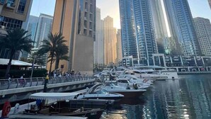 A marina with boats docked, surrounded by high-rise buildings with modern architecture. - StayShort - 2BR in Dubai Marina that Sleeps 6 with Water Views! (Dubai Marina)