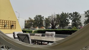 A hammock, outdoor seating area, and a yellow wall. - Casa Mar apartment, very close to Meia Praia beach, the Marina and the center of Lagos. (Lagos)