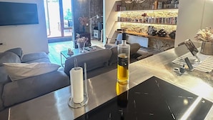 A modern kitchen with a built-in stove, a large window, and a stone wall in the background. - Designer apartment in Barcelona: Fully equipped 2-bedroom, the heart of the city (Barcelona)
