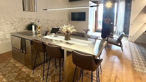A modern kitchen with a central island, bar stools, and a built-in oven. - Designer apartment in Barcelona: Fully equipped 2-bedroom, the heart of the city (Barcelona)