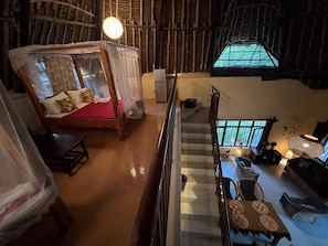A room with a bed, a staircase, a dining area, and a view through a window. - Kongo Dream Villa, a spacious 3-bedroom villa in Diani Beach with ocean (Kwale County)