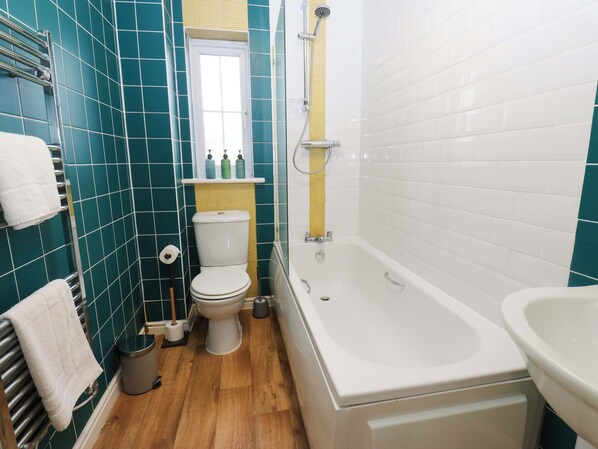 A bathroom with a toilet, bathtub, and sink. - Cottage Holiday Home (Huddersfield)