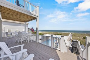 A wooden deck with white chairs and a pool, overlooking the beach. - Ocean Club of Kure Beach - Oceanfront, pet friendly home with Private pool & Hot (Kure Beach)