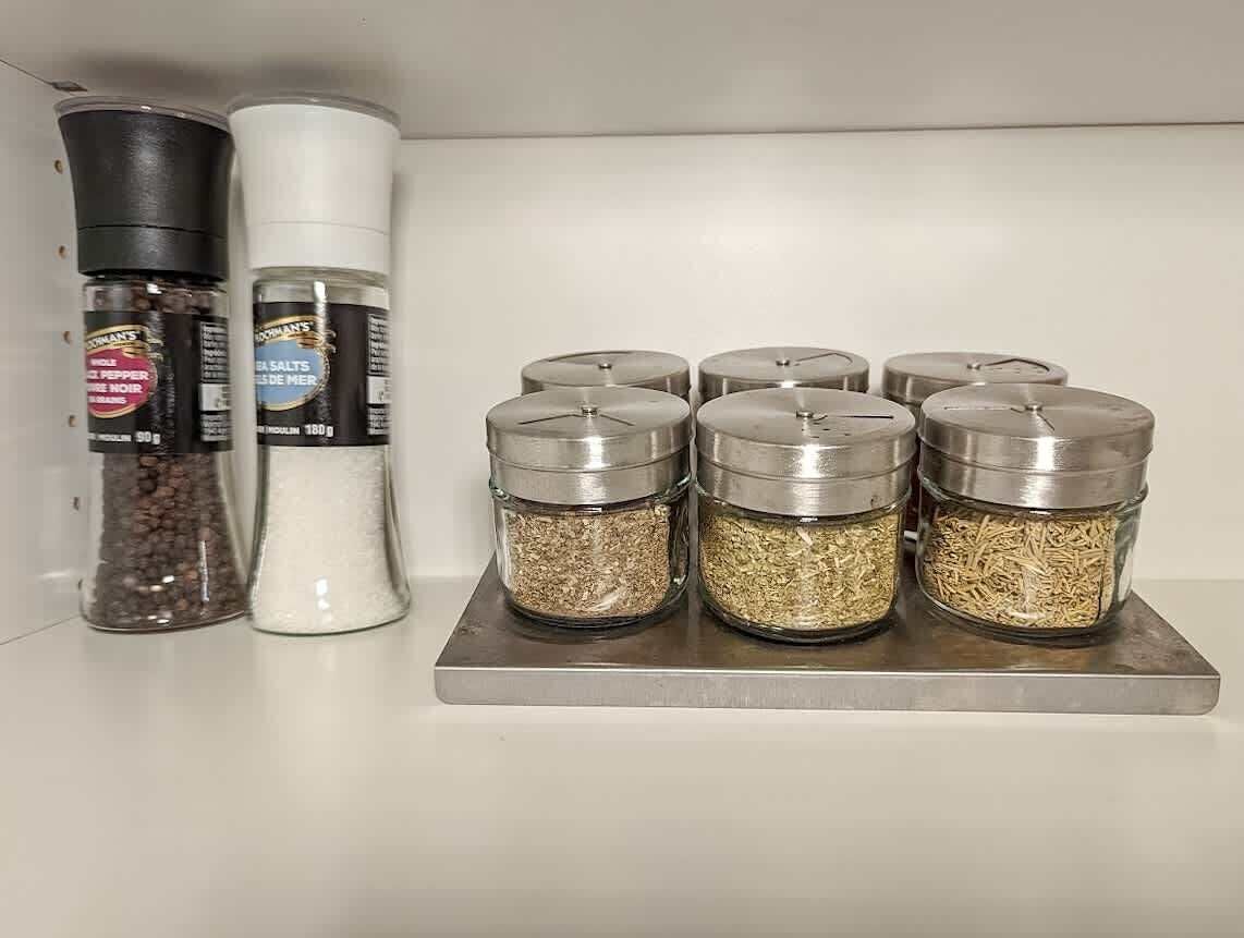 Keittiön työtaso, jossa on erilaisia maustepurkkeja ja pippurimyllyjä.