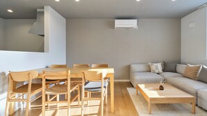 A modern living room with a dining table, chairs, a sofa, and a coffee table. - Higashikawa Hinna (Higashikawa)