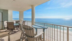 A balcony with a view of the ocean, featuring a table and chairs. - Big August Discounts! Spacious 3BR Oceanfront Unit W/Free Beach Chair Service (Panama City Beach)
