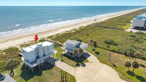 An aerial view of a coastal property with a beach, two large white buildings, and a clear view of the ocean. - Beachfront Beauty w/ Wraparound Deck & Private Dune Walkover (Galveston)