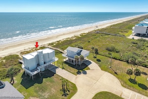 An aerial view of a coastal property with a beach, two large white buildings, and a clear view of the ocean. - Beachfront Beauty w/ Wraparound Deck & Private Dune Walkover (Galveston)