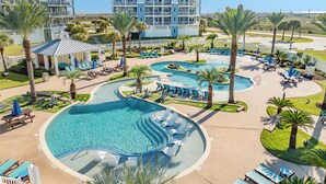 Un complexe hôtelier doté de plusieurs piscines, d’espaces de détente et d’un grand bâtiment avec des balcons.