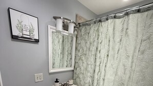 A bathroom with a toilet, sink, and shower curtain. - Ranch Cozy Home close to O'Hare (River Grove)