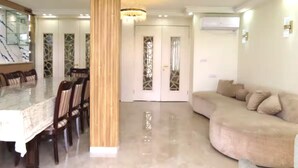 A modern living room with a marble dining table, a beige sofa, and a chandelier. - stunning appartment in jerusalem romema (Jerusalem)