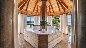 Un intérieur en bois avec un îlot central, de grandes fenêtres et une vue sur l’extérieur.