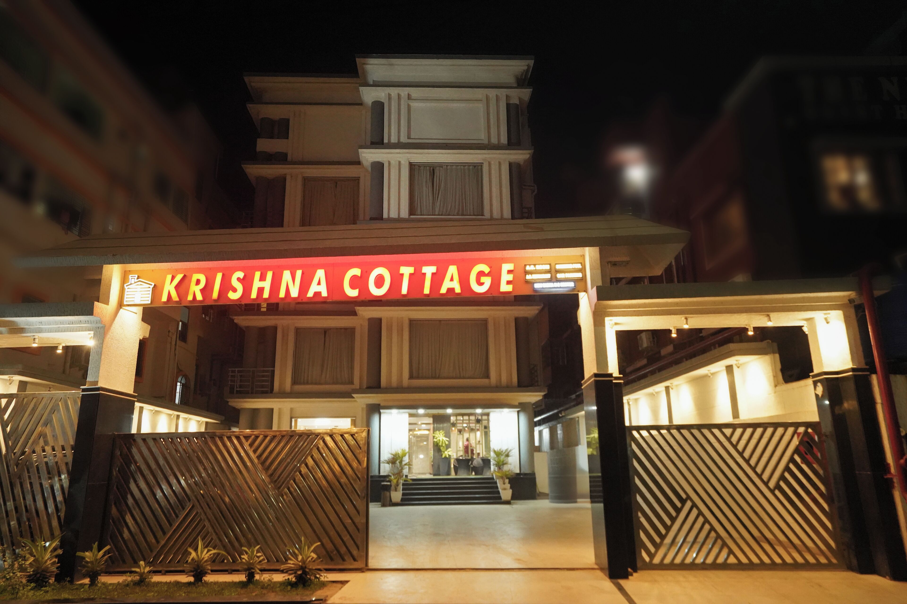 Der Eingang zum Krishna Cottage mit einem gut sichtbaren Schild, einem Eingangstor und einer Treppe, die zum Hauptgebäude führt.