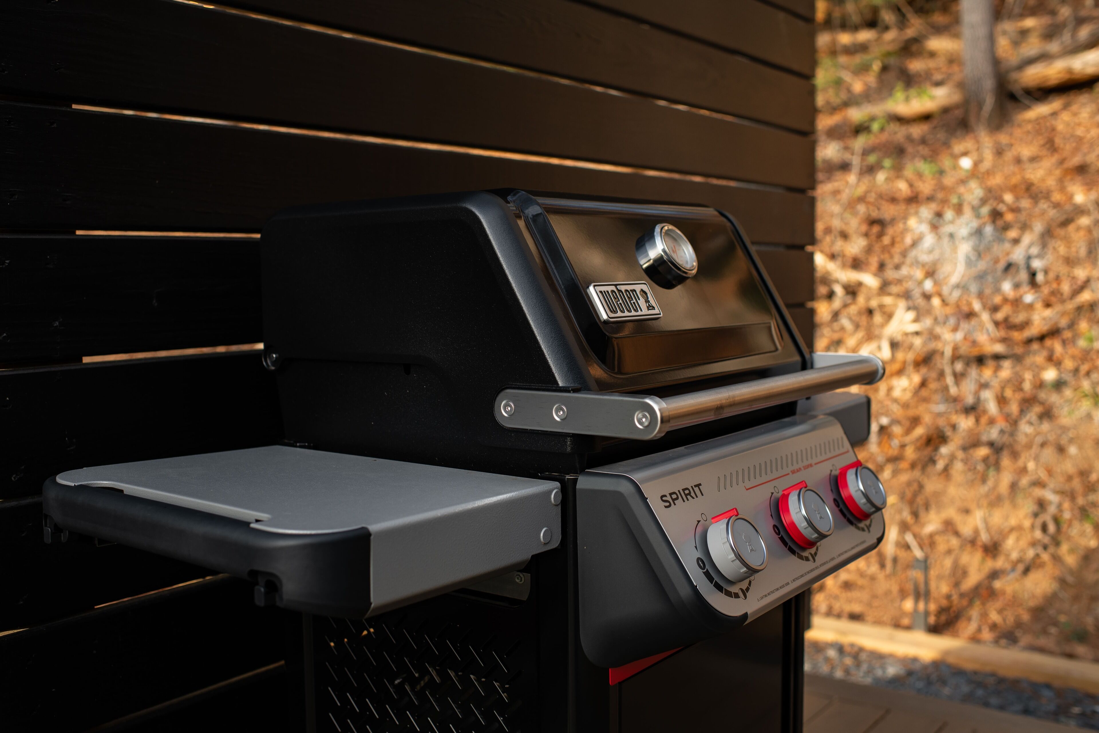 A barbecue grill with a digital display and control knobs.