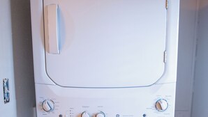 Eine weiße Waschmaschine ist in einem Waschraum aus der Front zu sehen.