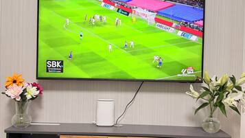 A flat-screen TV mounted on a wall, displaying a sports event.