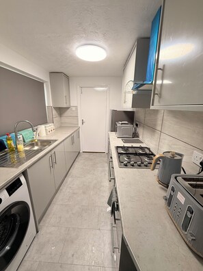 A modern kitchen with a stainless steel range, a built-in oven, and a dishwasher. - Cosy Two-bedroom Bungalow in the Centre of Sunderland (Sunderland)