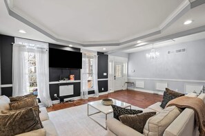 Un salon moderne avec un téléviseur à écran plat, un ensemble de canapés et une table basse.