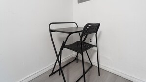 A small black metal table and chair set against a white wall, with a framed picture above the table. - Cozy Private 2 bedroom apartment, free Wifi, free parking in heart of Toronto (Toronto)