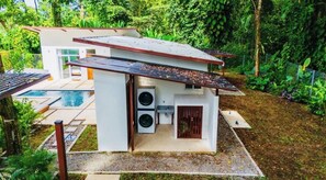 A modern house with a pool, a laundry area, and a fenced garden. - 3-Bedroom Jungle Villa with Pool & FirePit in lovely Puerto Viejo (Puerto Viejo de talamanca)