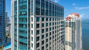A high-rise building with a modern glass facade, located near a body of water. - Stylish 1BR Brickell Retreat Walk to Everything (Miami)