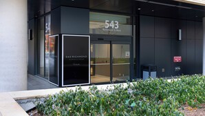A modern building with a large glass entrance, a sign reading "543 Richmond St West," and a "No Smoking" sign on the wall.