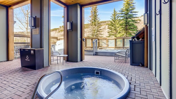 A hot tub on a patio with a view of trees and mountains. - ★★ KEYSTONE CONDO ★★ Ski in/out - RiverRun Village 1BD 1BA (Keystone)