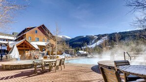 A wooden lodge with a hot spring, outdoor seating, and a view of snow-covered mountains. - ★★ KEYSTONE CONDO ★★ Ski in/out - RiverRun Village 1BD 1BA (Keystone)