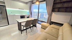 Eine moderne Wohnung mit Küche, Essbereich und einem Balkon mit Blick auf die Stadt.