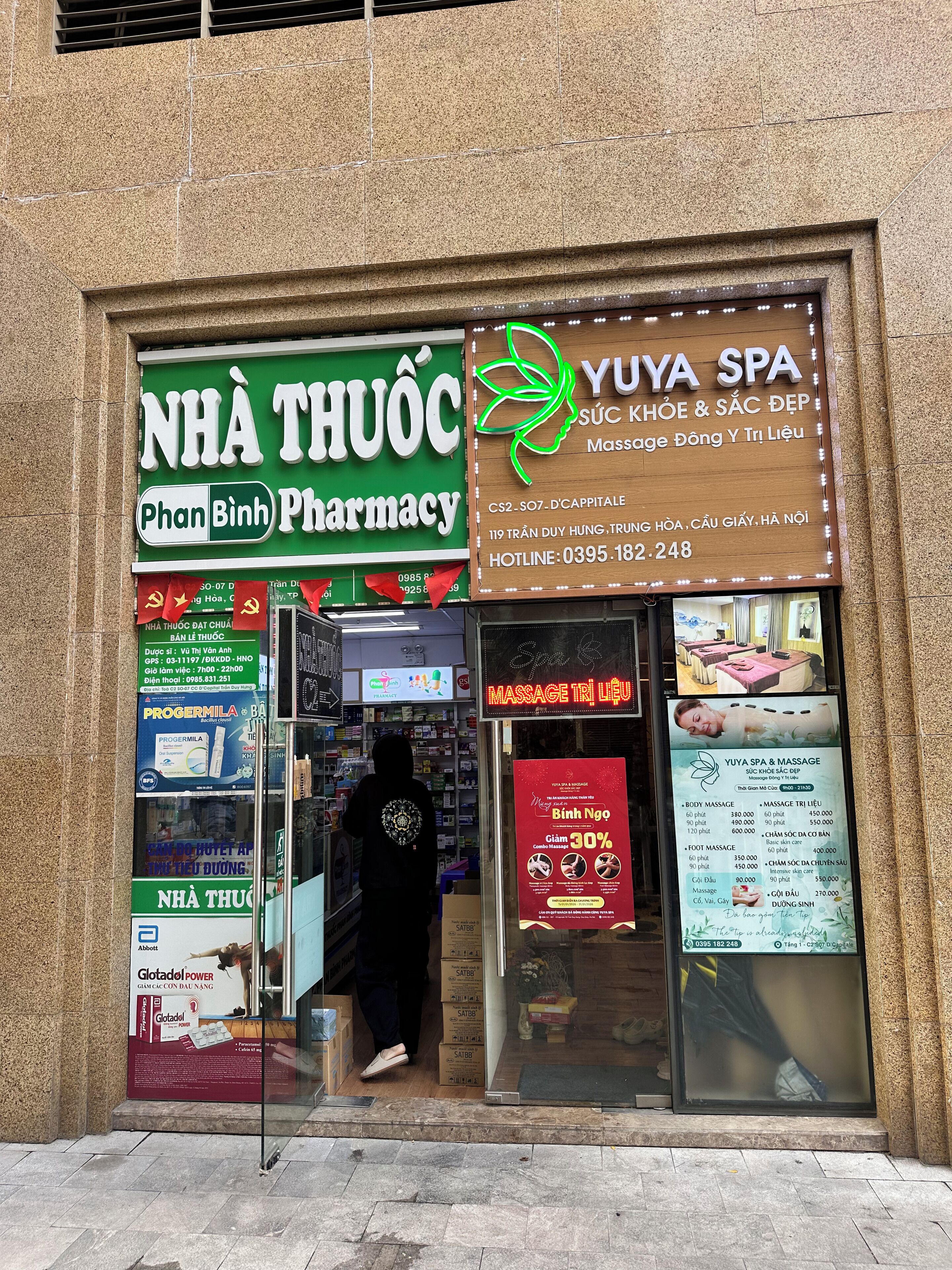 A pharmacy and a spa with visible signage and a person entering.