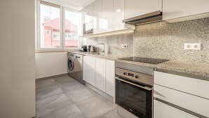 Eine moderne Küche mit Geschirrspüler, Backofen und Spritzschutz aus Granit.