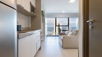 Una cocina moderna con vista al mar, una sala de estar con sofá y una puerta con cerradura de llave.