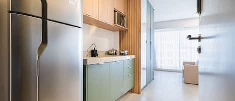 Une cuisine moderne dotée d’un réfrigérateur en acier inoxydable, de meubles en bois et d’un plan de travail équipé d’appareils électroménagers.