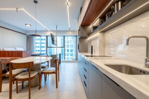 Een moderne keuken met een groot eiland, inbouwapparatuur en een strakke kraan.